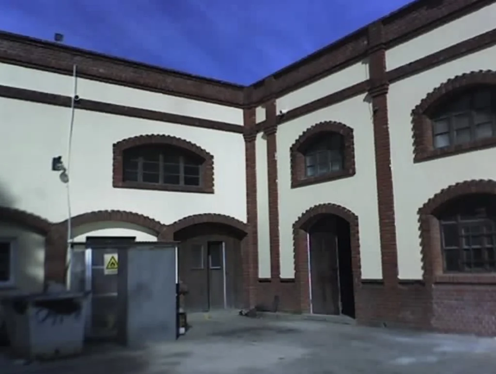 Planta AYSA Vicente López — esquina de edificio con ladrillo visto y revoque